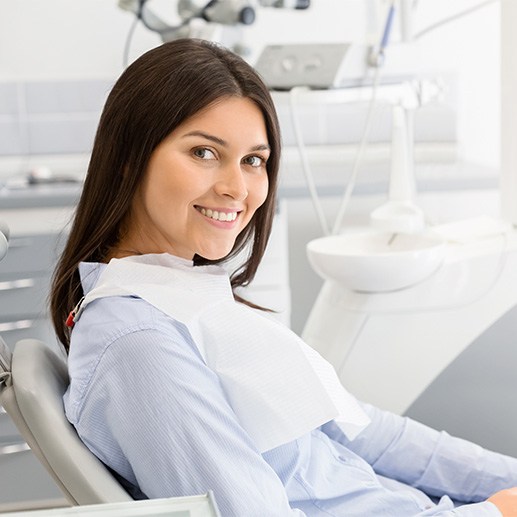 Woman sitting in chair at dentist’s office and smiling