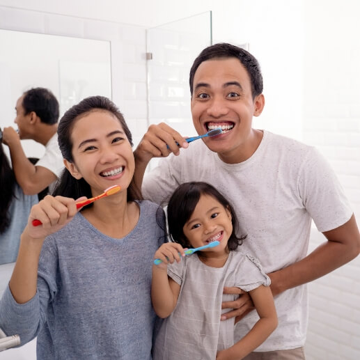 Family of three brushing their teeth