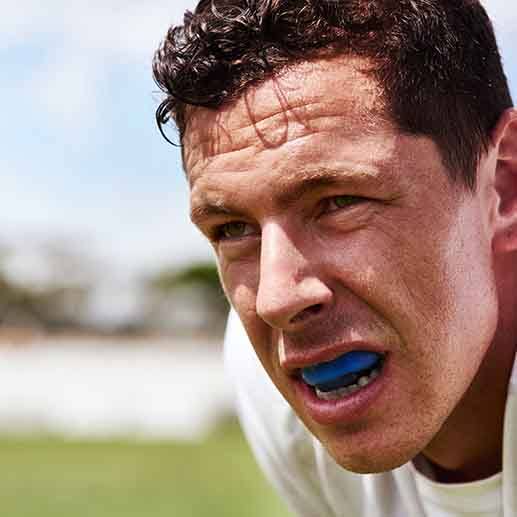 Closeup of man wearing blue mouthguard outside