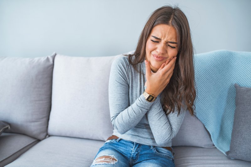 A young woman suffering from severe toothaches