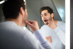 Man examining his mouth for oral bumps